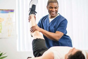 Male physiotherapist helping patient