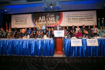 OPSEU President Warren (Smokey) Thomas introducing the We Own It mobilizers standing behind him onstage during Convention 2017 Day 1