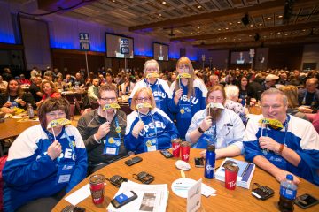 OPSEU members wearing OPSEU hockey shirts and holding campaign moustaches to their faces during Convention 2017 Day 2