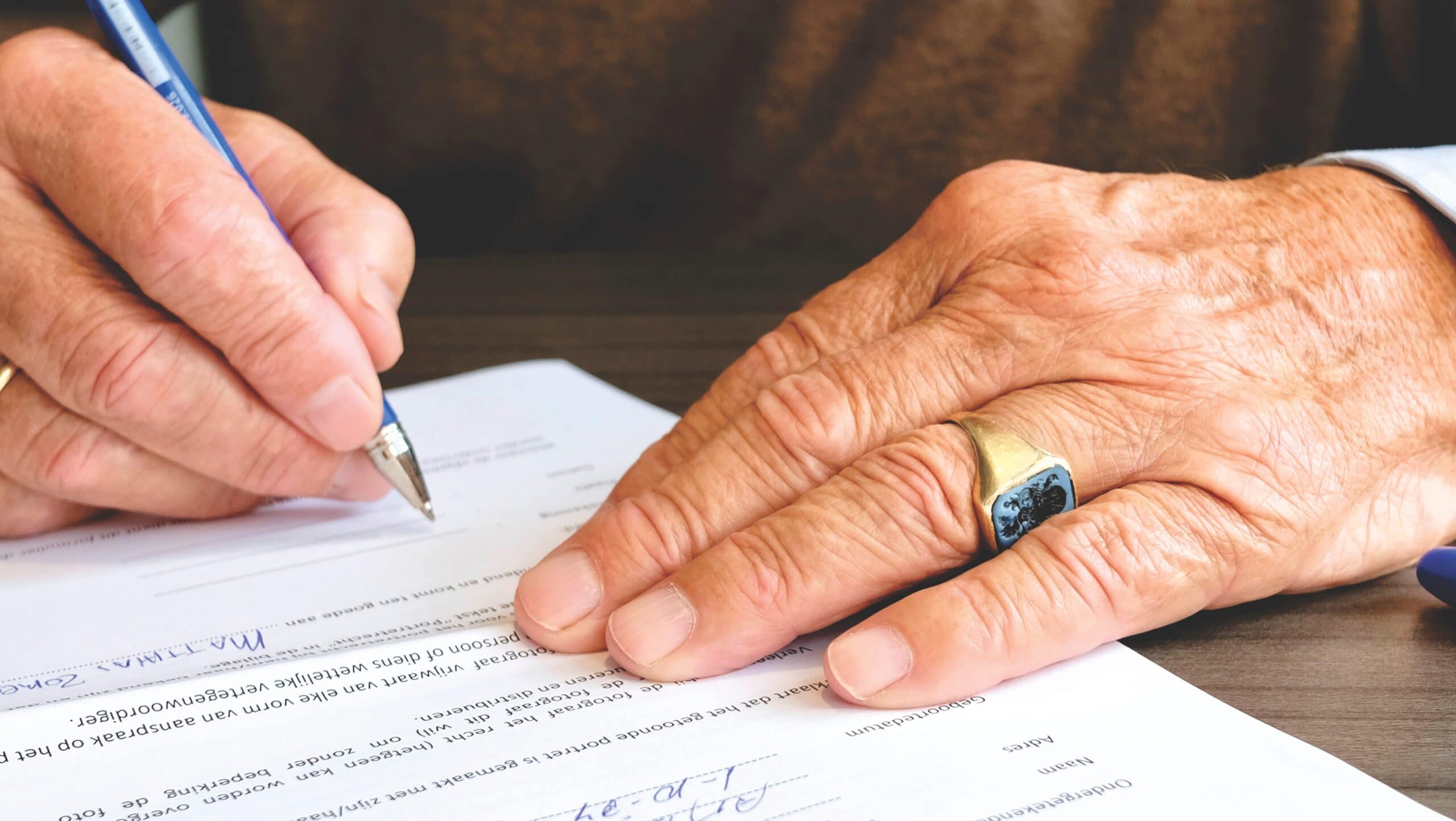 Photo of hands signing a document