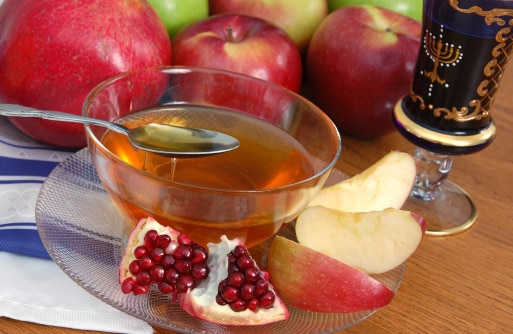 Apples, pomegranate, and honey arranged for a Rosh Hashanah celebration.