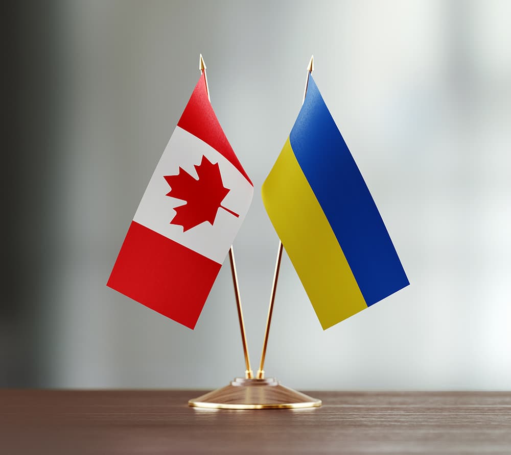 Crossed table flags of Canada and Ukraine on a desk